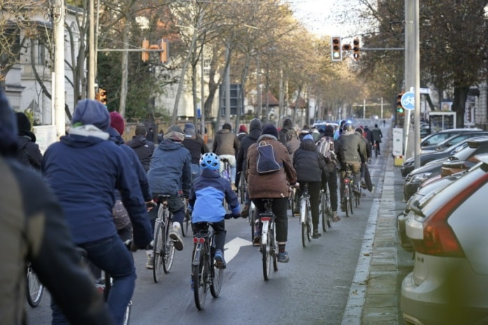 Über hundert Menschen fahren mit dem Fahrrrad auf einer Straße.