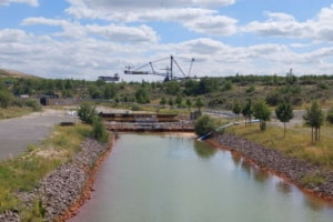 Neu gebauter Kanal zwischen zwei Tagebauseen, im Hintergrund steht ein historischer Absetzer.
