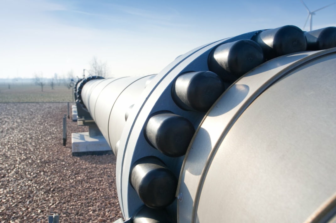 Massive Erdgaspipeline mit starker Verschraubung läuft über Kies-Untergrund