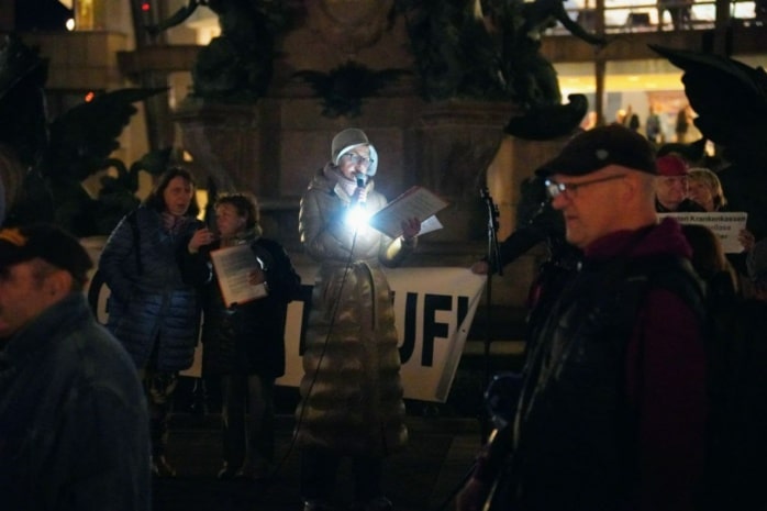 Eine Person spricht auf einer Demonstration in ein Mikrofon.