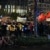 Mehrere hundert Menschen demonstrieren auf dem Augustusplatz mit Bannern und größtenteils roten Fahnen in der Hand.