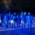 Eine dichte Polizeikette hindert Personen am Weiterlaufen, diese wir von Blaulicht angestrahlt.