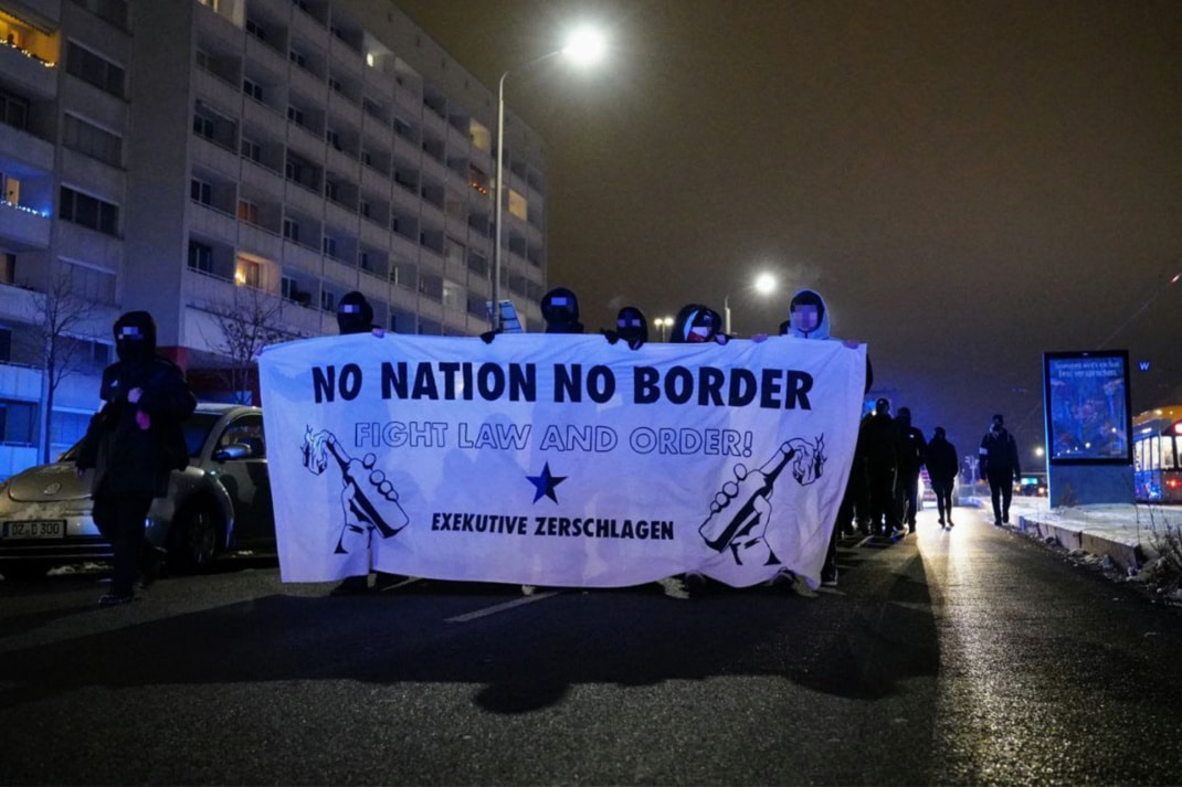 Mehrere Personen, die ein Banner halten mit der Aufschrift "No Nation, no Border"
