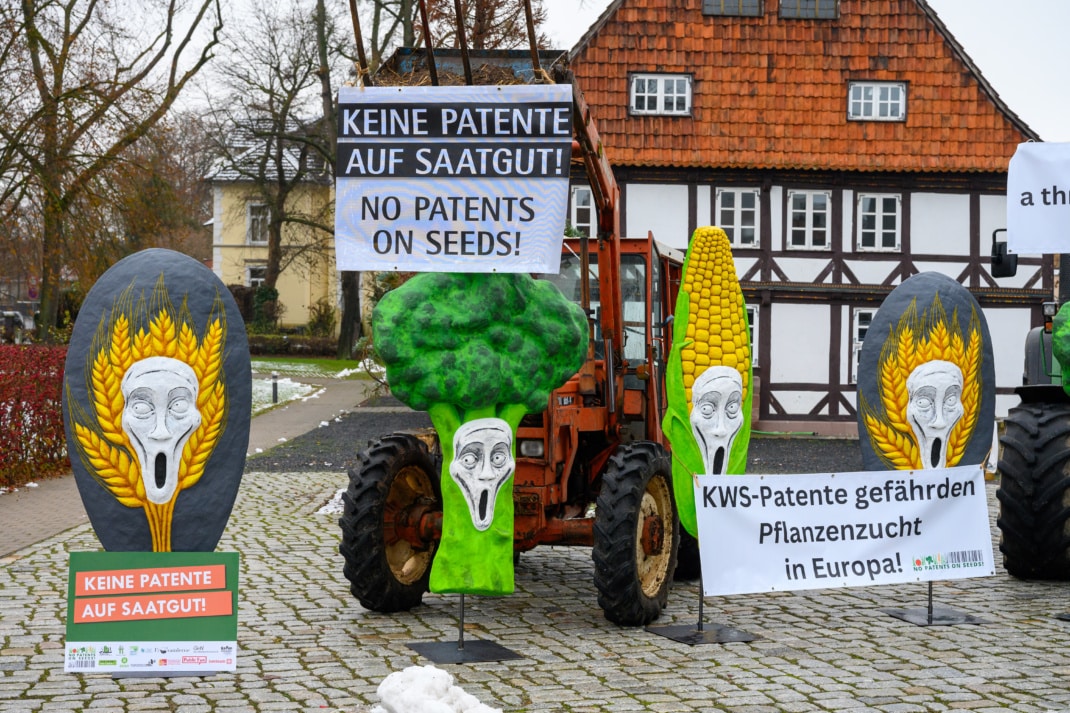 Banner mit Sprüchen und Pappgemüse vor einem Trecker