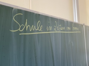 Schule in Zeiten von Corona lautet die Aufschrift auf der Klassenzimmer-Tafel.