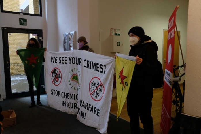 Aktivisten mit Bannern im SPD-Büro. Darauf zu sehen sind kurdische Symbole und die Forderung, den Chemiewaffen-Einsatz zu stoppen
