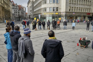 Menschen stehen auf dem kleinen Wilhelm-Leuschner-Platz in einem Kreis