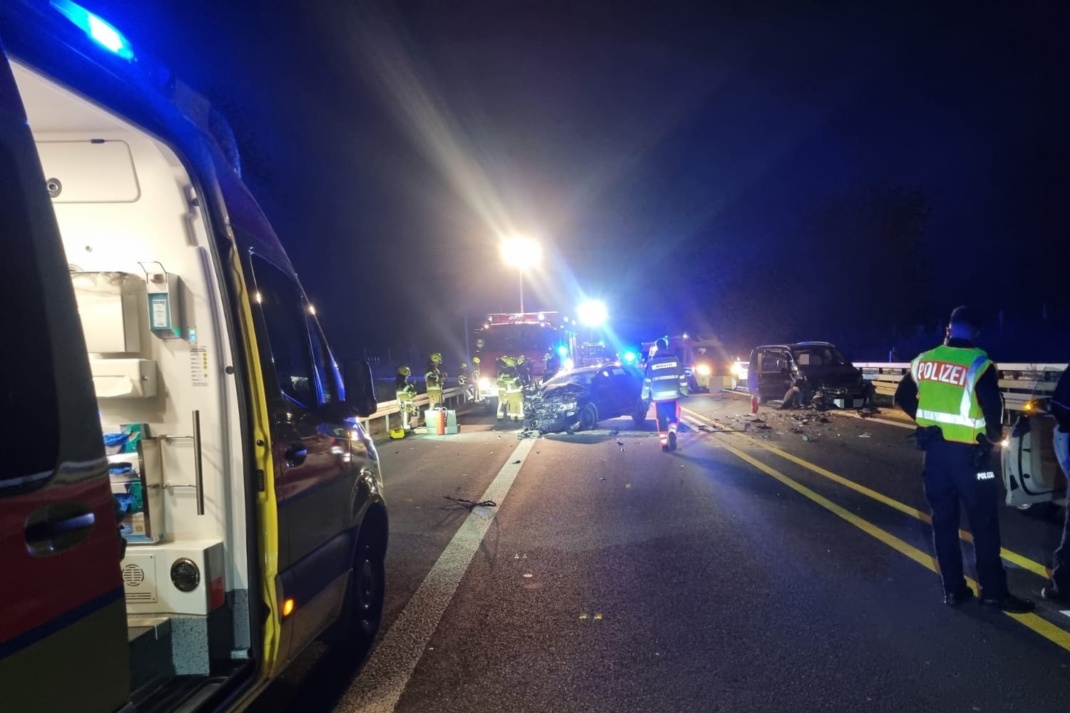 Zwei der betwiligten Unfallwagen auf der Autobahn, davor ein Rettungswagen und Polizei
