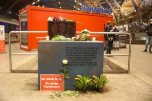 Das Denkmal mit Blumen davor und einem Schild mit der Aufschrift Nie wieder Krieg