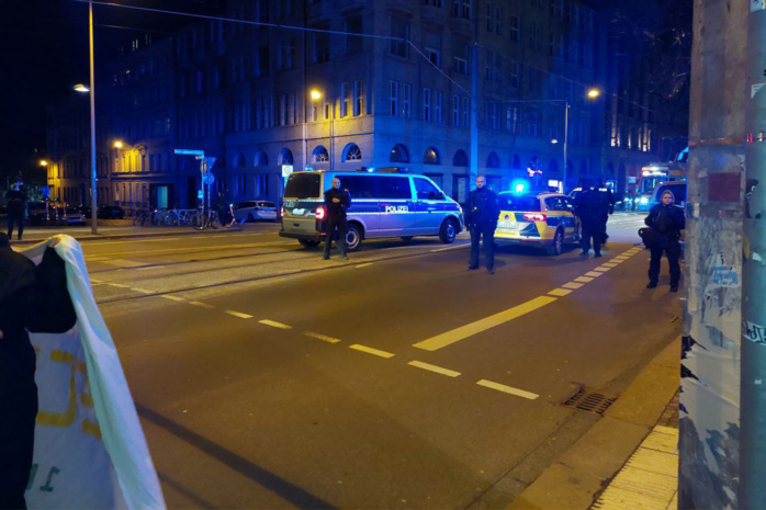 Polizeiwagen und Einsatzkräfte auf der Karl-Liebknecht-Straße am Abend