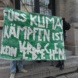 Mehrere Menschen halten vor dem Leipziger Amtsgericht ein Plakat mit dem Schriftzug „Fürs Klima kämpfen ist kein Verbrechen“ in die Höhe.