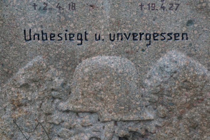 Die Inschrift "Unbesiegt und unvergessen" auf einem Stein