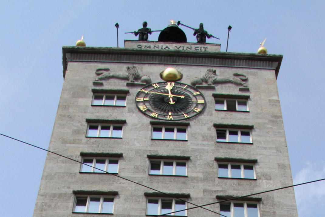 Figuren auf dem Leipziger Kroch-Hochhaus aus Gehsteig-Perspektive.