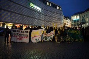 Zu sehen sind mehrere dutzend Menschen vor der Blechbüchse. Sie halten mehrere Banner. Darauf stehen Botschaften zu Klima, Lützerath und Kapitalismus.