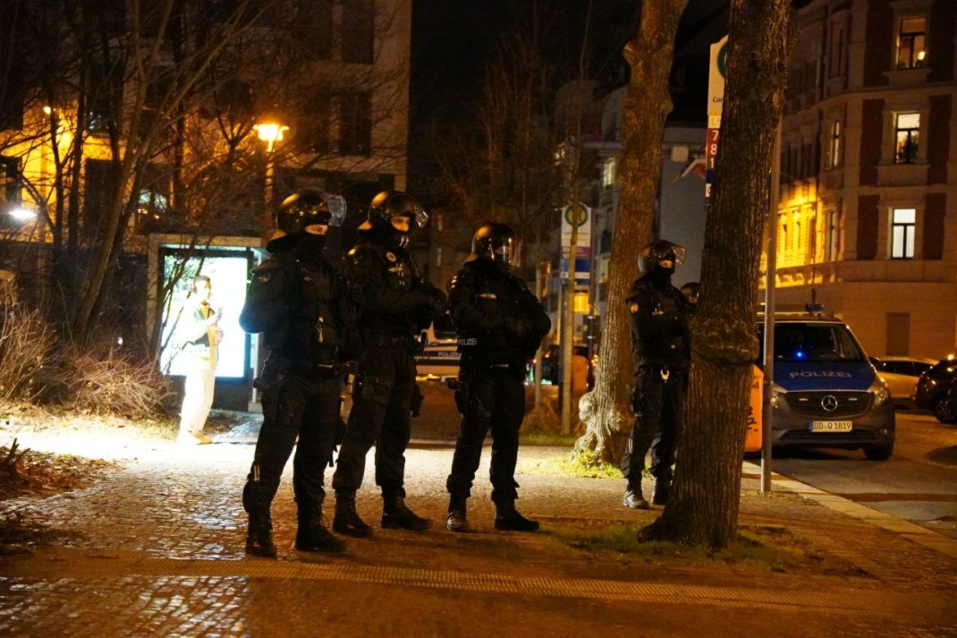 Vier behelmte Polizisten am Rande der Demonstration