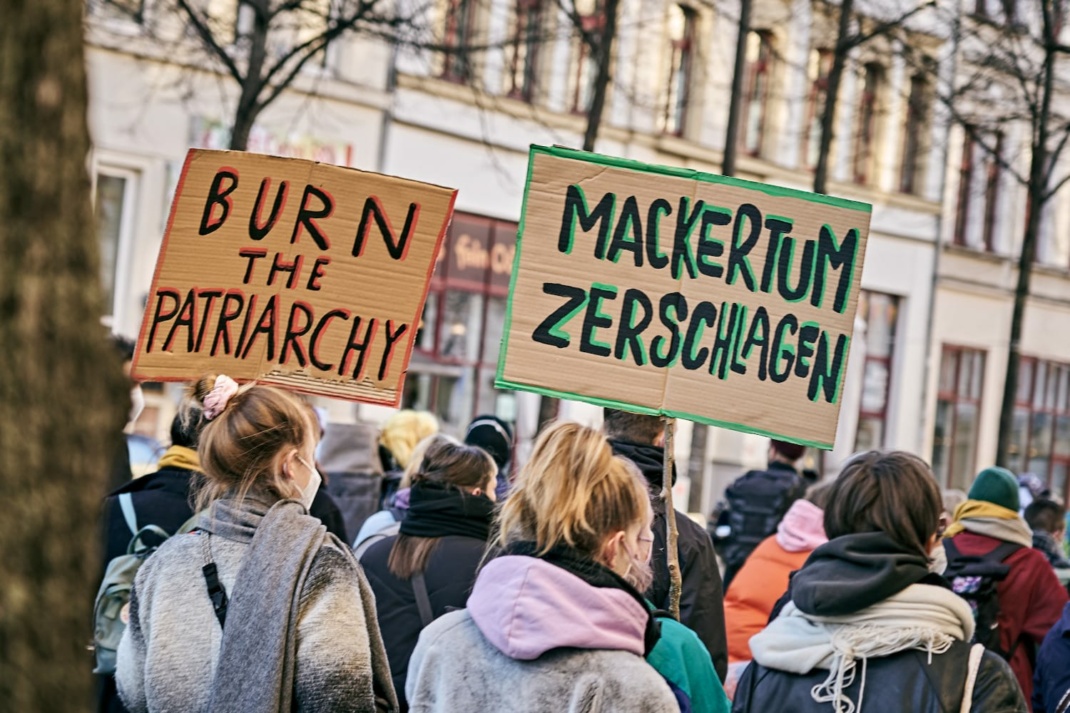 Teilnehmende einer Demo mit Schildern.