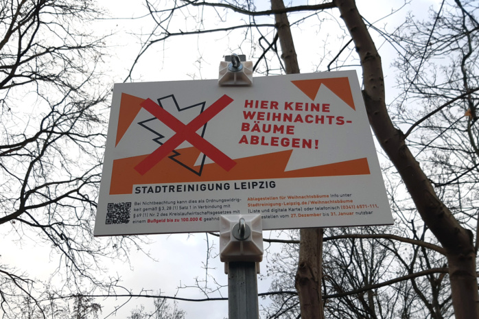Ein rechteckiges Schild der Stadtreinigung auf der Erich-Zeigner-Allee in Plagwitz, das darauf hinweist, dass sich hier eine nicht genehmigte Stelle zur Ablage von Weihnachtsbäumen befindet.
