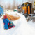 Spielende Kinder im Schnee, im Hintergrund sind Bauwagen zu sehen