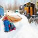 Kinder spielen im Schnee, im Hintergrund sind Bauwagen zu sehen.