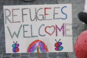Schild in bunten Farben mit der Aufschrift: Refugees Welcome