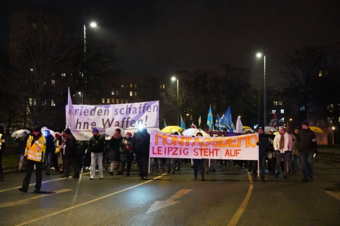 Personen auf dem Leipziger Ring mit Bannern