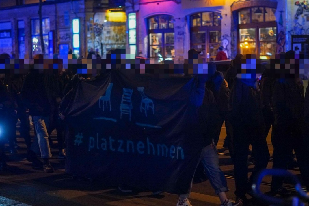 Dunkel gekleidete Personen in einem Demonstrationszug