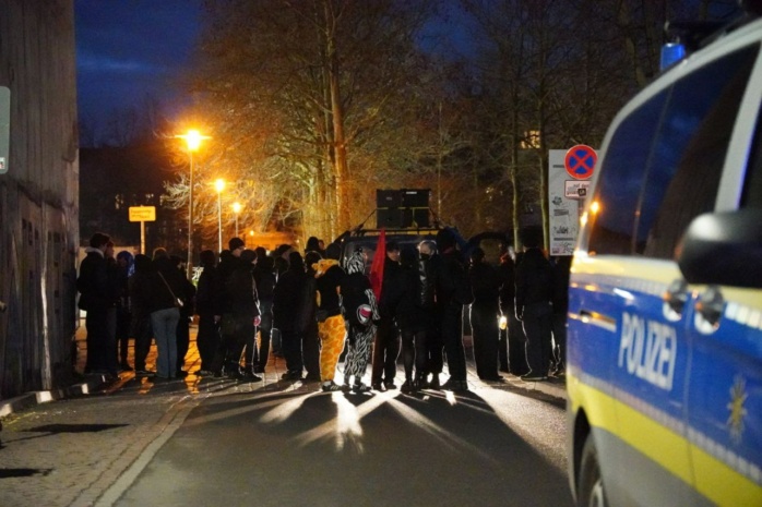 Eine Gruppe verkleideter Personen, im Vordergrund ein Polizeiwagen
