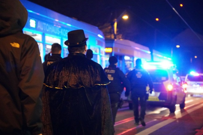 Verkleidete Personen, zu sehne von hinten mit Blaulicht angestrahlt