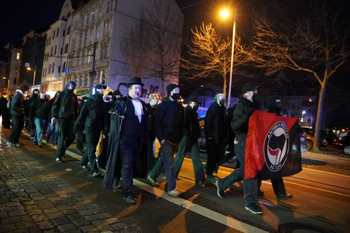 Verkleidete Personen mit antifaschistischem Banner
