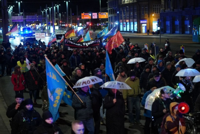 Personengruppe mit Flaggen und Schirmen