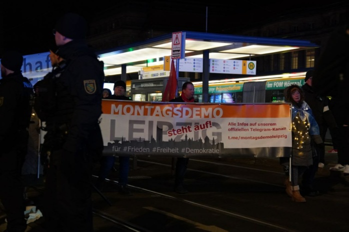 Personengruppe trägt Banner vor sich her