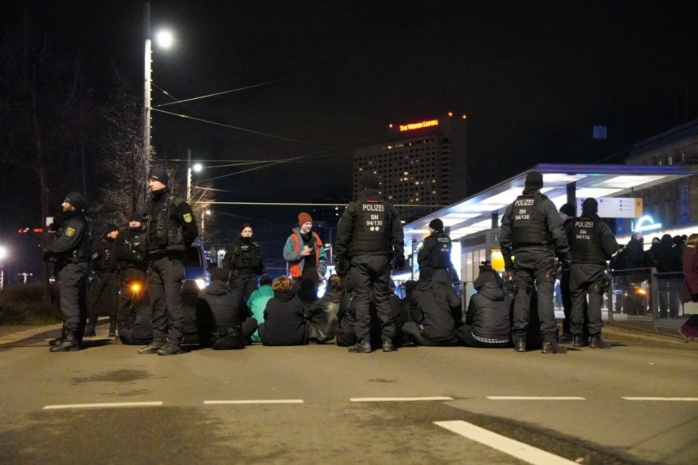 Personen blockieren sitzend eine Straße
