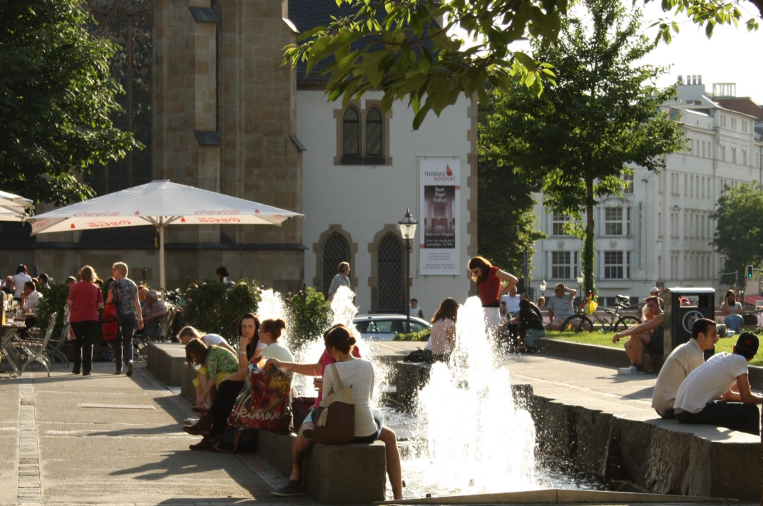 Menschen sitzen am Brunnen.