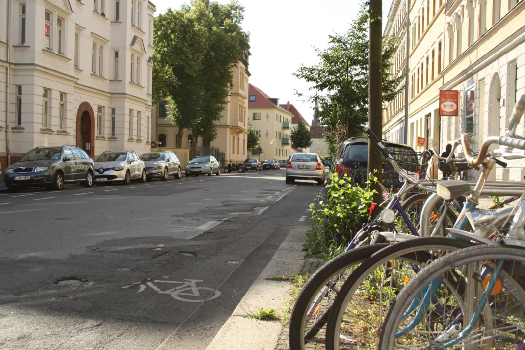 Straßenrand mit Grasbewuchs und Fahrrädern.