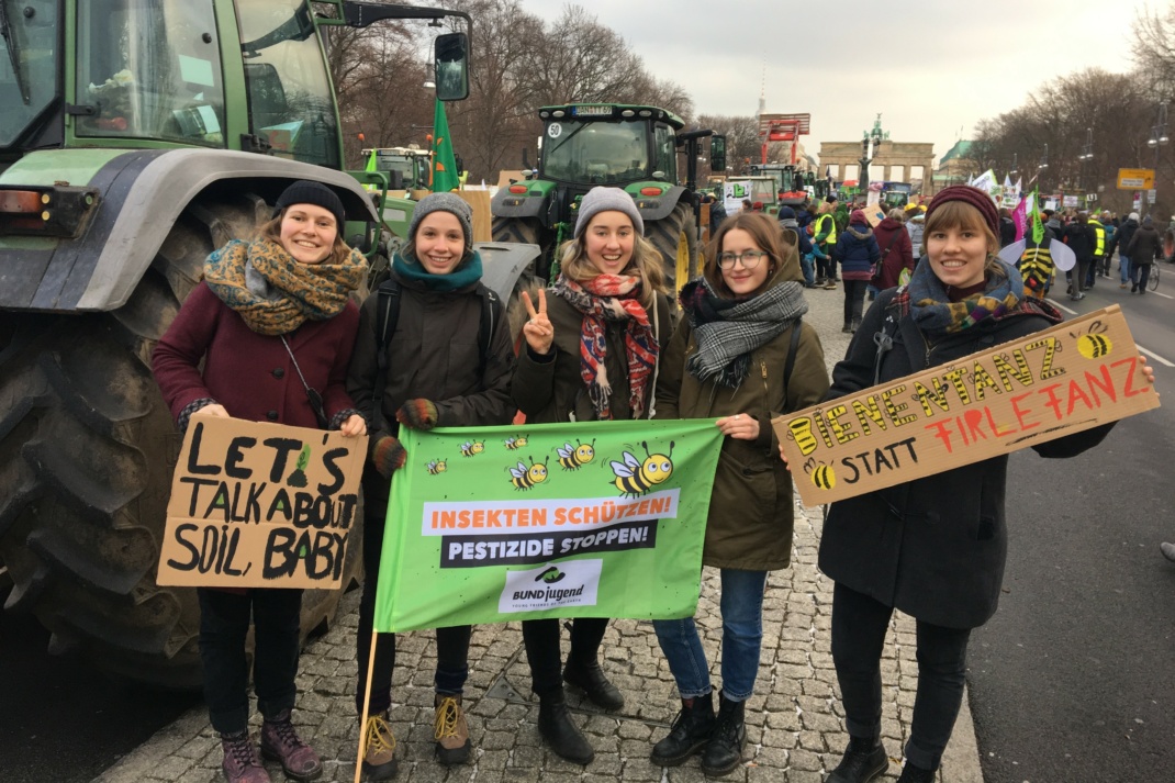 Fünf Frauen mit Umweltschutzbannern vor einem Trecker