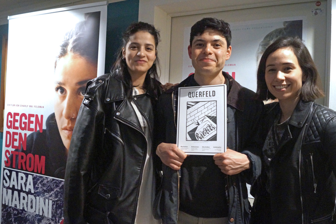 Sara Mardini, Seán Dinder und Charly Wai Feldman neben dem Filmplakat „Gegen den Strom“. Foto: Yaro Allisat