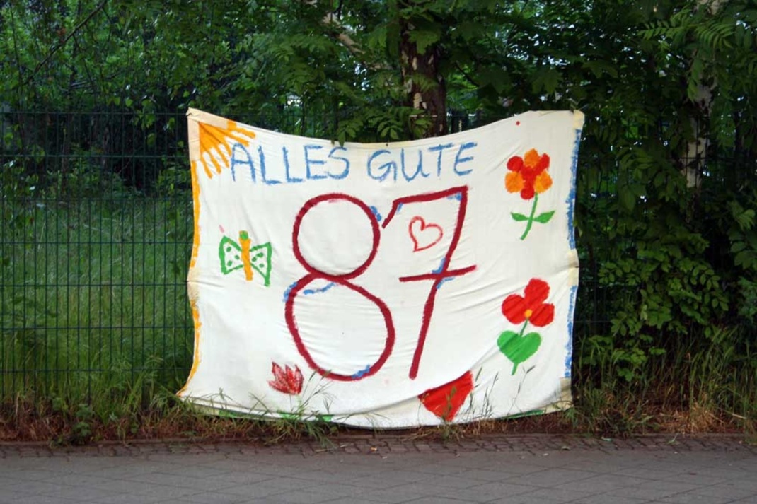 Bunt bemaltes Transparent mit der Aufschrift: Alles Gute zum 87. Geburtstag
