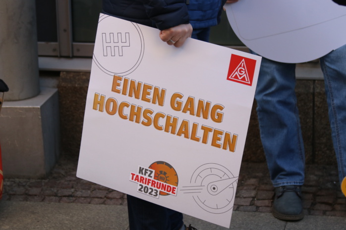 Mitglieder der Gewerkschaft IG Metall mit Plakaten fordern mehr Lohn und Inflationsausgleich im Kfz-Handwerk