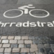 Ausweisung als Fahrradstraße auf Asphalt.