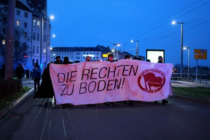 Gruppierung hinter einem Banner mit der Aufschrift "Die Rechten zu Boden"