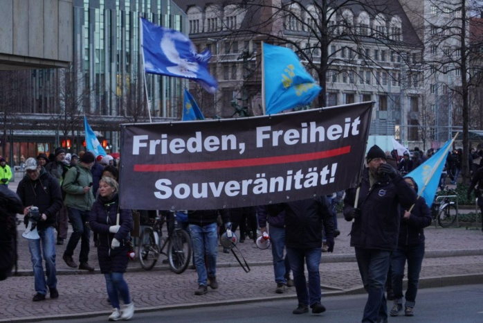 Personengruppe mit einem Banner mit der Aufschrift "Frieden, Freiheit, Solidarität"