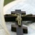 Ein Holzkreuz mit einer Jesusfigur liegt auf einer aufgeschlagenen Bibel.
