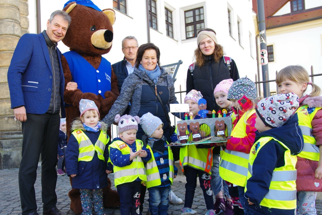 Landrat Kai Emanuel (links) mit dem TZ-Maskottchen Torgi-Bär und den Kita-Kindern, die ihre Bastelarbeit zeigen. Foto: LRA/Stöber