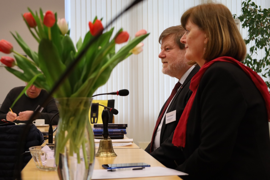 Zwei Personen, Tischplatte und Blumen.