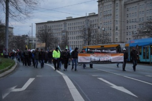 Mehrere Personen auf der Straße, ein Banner tragend