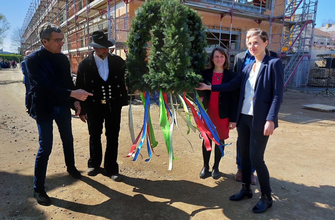 Vier Personen mit Kranz zum Richtfest.