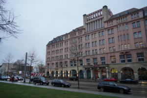 Volkshaus an der Karl-Liebknecht-Straße, davor Autos und Personen.