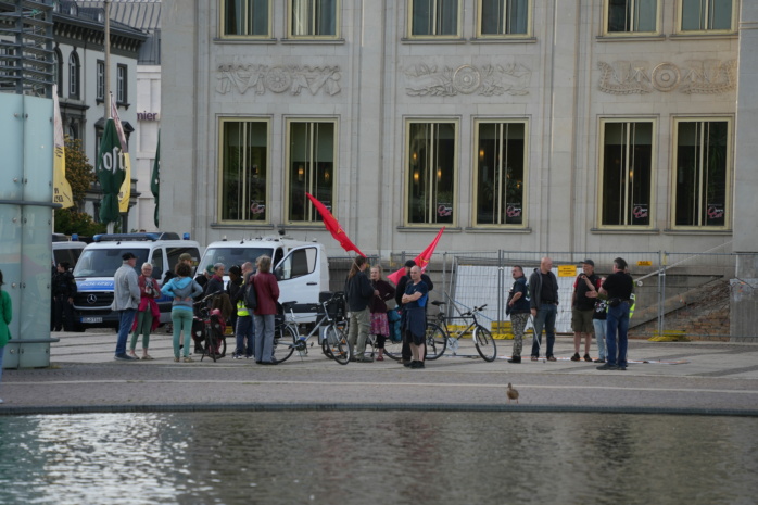 Perosnengruppe vor einem Brunnen mit Fahnen und Bannern