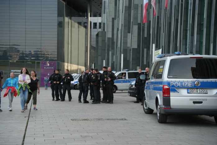 Personengruppe, im Vorderund Polizeiautos
