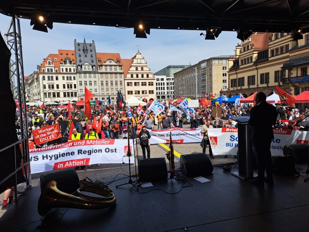 Menschenmenge auf einem Platz, beobachtet vom Hintergrund einer Bühne